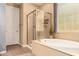 Bathroom featuring a standalone tub, large glass shower, neutral wall colors and a window at 25862 N 108Th Ave, Peoria, AZ 85383