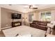 Cozy living room with a leather sofa, large windows, ceiling fan, and an area rug at 25862 N 108Th Ave, Peoria, AZ 85383