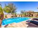 Relaxing pool area with lounge chairs, rock water feature, and lush landscaping at 25862 N 108Th Ave, Peoria, AZ 85383