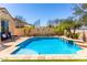 Beautiful backyard pool with tile accents, desert landscaping, and lounge chairs at 25862 N 108Th Ave, Peoria, AZ 85383