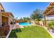 Inviting backyard oasis with a sparkling pool, artificial grass, and mature trees at 25862 N 108Th Ave, Peoria, AZ 85383