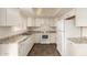 Well-lit kitchen boasts white cabinetry, granite countertops, a white refrigerator, oven, and a tile floor at 27 W Concorda Dr # 104, Tempe, AZ 85282