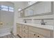 Well-lit bathroom with dual sinks, large mirror, and a shower/tub combo behind a closed door at 2806 E Pontiac Dr, Phoenix, AZ 85050