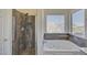 Bathroom featuring walk-in shower with stone floor and soaking tub beneath a window for ample natural light at 2806 E Pontiac Dr, Phoenix, AZ 85050