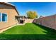 The bright backyard includes a spacious grassy area, a covered patio, and a block wall fence at 3017 W Matthew Dr, Phoenix, AZ 85027
