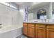 Bathroom with a shower-tub combo, wood cabinets, and a large mirror at 3017 W Matthew Dr, Phoenix, AZ 85027