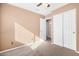 Bright bedroom features neutral carpet, a ceiling fan, and a closet with sliding doors at 3017 W Matthew Dr, Phoenix, AZ 85027