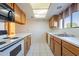 Well lit kitchen with white appliances, neutral countertop and wood cabinets at 3031 N Civic Center Plz # 255, Scottsdale, AZ 85251