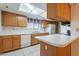 Well lit kitchen with white appliances, neutral countertop and wood cabinets at 3031 N Civic Center Plz # 255, Scottsdale, AZ 85251
