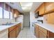 Well lit kitchen with white appliances, neutral countertop and wood cabinets at 3031 N Civic Center Plz # 255, Scottsdale, AZ 85251