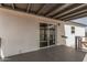 A covered back porch with sliding glass door and gray painted floor provide outdoor living at 30433 W Bellview St, Buckeye, AZ 85396