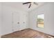 A bedroom with wood floors, ceiling fan, two closets, and a window at 30433 W Bellview St, Buckeye, AZ 85396