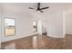 This bedroom features wood floors, white walls, two windows, and an ensuite bathroom at 30433 W Bellview St, Buckeye, AZ 85396