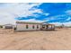 Charming single-story home featuring a cozy front porch and a detached garage on a spacious lot under a partly cloudy sky at 30433 W Bellview St, Buckeye, AZ 85396