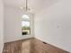 Bright living room featuring wood floors, modern lighting, and a half-moon window at 30433 W Bellview St, Buckeye, AZ 85396