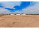 Wide view of the property with a home and outbuildings on a spacious lot under a partly cloudy sky at 30433 W Bellview St, Buckeye, AZ 85396