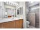 Well-lit bathroom with vanity, large mirror, and a separate shower with tile surround at 30458 N Sunray Dr, San Tan Valley, AZ 85143