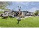 Expansive backyard offering artificial turf, an outdoor dining area, covered patio, and a versatile entertaining space at 3246 E Palm Ln, Phoenix, AZ 85008
