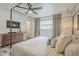 Comfortable bedroom featuring a four-poster bed, hardwood floors, a ceiling fan, and a dresser at 3246 E Palm Ln, Phoenix, AZ 85008