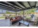 Relaxing covered patio with comfortable seating, ceiling fan, outdoor lighting, and views of the landscaped backyard at 3246 E Palm Ln, Phoenix, AZ 85008