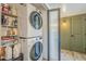 Laundry room with stacked washer and dryer, shelving, hardwood floors, and a door at 3246 E Palm Ln, Phoenix, AZ 85008