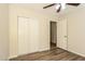 This bedroom features wood-look floors, closet with sliding doors, and an open doorway to another room at 3323 W Fraktur Rd, Phoenix, AZ 85041