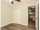 This bedroom has wood-look floors, closet with sliding doors, and an adjacent kitchen visible through the open doorway at 3323 W Fraktur Rd, Phoenix, AZ 85041