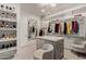 Bright walk-in closet with custom shelving and drawers, closet island, and stylish seating at 340 E Osborn Rd # 3, Phoenix, AZ 85012