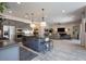 Open-concept kitchen with island seating, gray cabinets, and adjacent living area at 3429 E Constance Way, Phoenix, AZ 85042