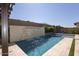 Beautiful pool featuring a modern waterfall, integrated hot tub, and sleek stone tiling at 3429 E Constance Way, Phoenix, AZ 85042