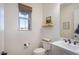 Stylish powder room featuring a pedestal sink, wood shelf, and window for natural light at 3429 E Constance Way, Phoenix, AZ 85042