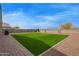 Spacious back yard with artificial turf, desert landscaping, and rock ground covering at 3818 N 306Th Ave, Buckeye, AZ 85396