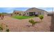 Back yard featuring artificial grass, cacti, desert landscaping, and a covered patio at 3818 N 306Th Ave, Buckeye, AZ 85396