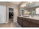 Spacious bathroom with double vanity, large mirror, decorative accents, and an open walk-in closet nearby at 3818 N 306Th Ave, Buckeye, AZ 85396