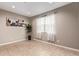 A well-lit room with a neutral color palette, tile floors, a potted plant, artwork, and natural light from the window at 3818 N 306Th Ave, Buckeye, AZ 85396