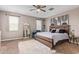 Cozy bedroom with a modern bed frame, area rug, ceiling fan, and natural light coming through multiple windows at 3818 N 306Th Ave, Buckeye, AZ 85396
