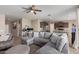 Inviting living room featuring a large sectional sofa, ceiling fan, and a view of the kitchen and office area at 3818 N 306Th Ave, Buckeye, AZ 85396