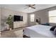 Bright main bedroom with a ceiling fan, dresser, mounted television, and calming neutral paint at 3818 N 306Th Ave, Buckeye, AZ 85396