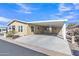 Tan home with covered carport providing ample parking and shade, complemented by easy-care landscaping at 40511 N Birdie St, San Tan Valley, AZ 85140