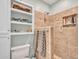 Bathroom featuring a tiled shower with tiled niche, updated fixtures and built in shelving at 4139 W Anderson Dr, Glendale, AZ 85308