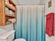 Bathroom features a modern shower curtain and functional wood shelving with rolled towels at 4139 W Anderson Dr, Glendale, AZ 85308