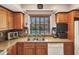 Kitchen showcasing the stainless steel sink under a window with a view to the backyard pool at 4139 W Anderson Dr, Glendale, AZ 85308