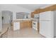 Bright kitchen featuring oak cabinets, white appliances, and an open pass-through to the dining area at 4213 E Shapinsay Dr, San Tan Valley, AZ 85140