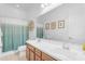Bright bathroom featuring a double vanity, large mirror, and a shower with a decorative curtain for elegance at 4247 S Zenith --, Mesa, AZ 85212