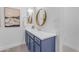 Stylish bathroom featuring a navy blue vanity, brushed gold fixtures, and round mirrors with contemporary decor at 4247 S Zenith --, Mesa, AZ 85212