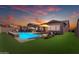 Backyard pool with lounge seating and umbrellas against a colorful sunset sky at 4247 S Zenith --, Mesa, AZ 85212