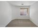 Empty bedroom featuring neutral carpet, and a window overlooking backyard at 44271 W Oster Dr, Maricopa, AZ 85138