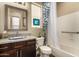 Well-lit bathroom with granite counters, dark wood cabinets, and shower-tub combo at 4516 E Walter Way, Phoenix, AZ 85050
