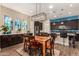 Inviting dining area featuring a modern chandelier, bar seating, and views into the kitchen at 4516 E Walter Way, Phoenix, AZ 85050