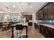 Modern kitchen with dark cabinets, stainless steel appliances, and large island with granite countertops at 4516 E Walter Way, Phoenix, AZ 85050